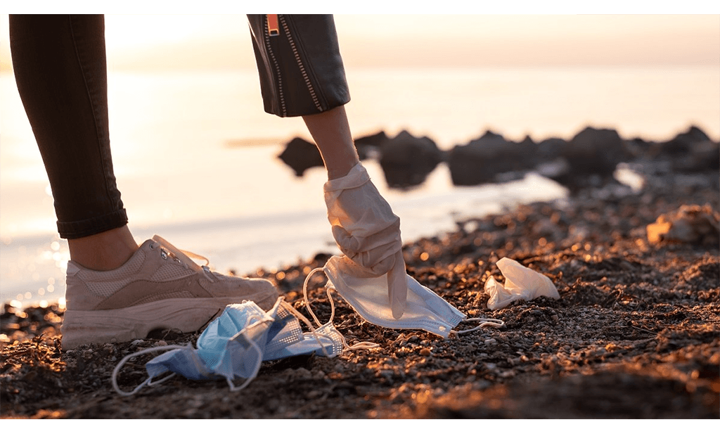 A photo of someone picking rubbish from a beach