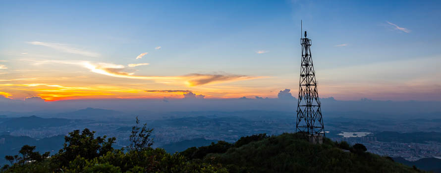 A photograph of a communications antenna with sunset in the background