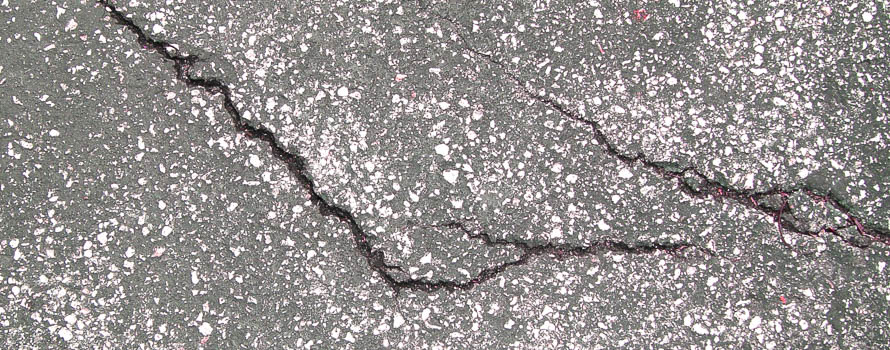 A photograph of cracks in a concrete road following an earthquake
