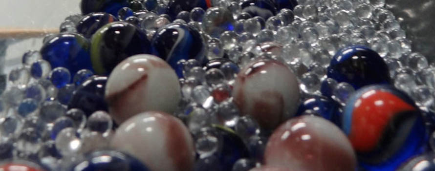 A mixture of two different sizes of glass marbles flowing along a channel