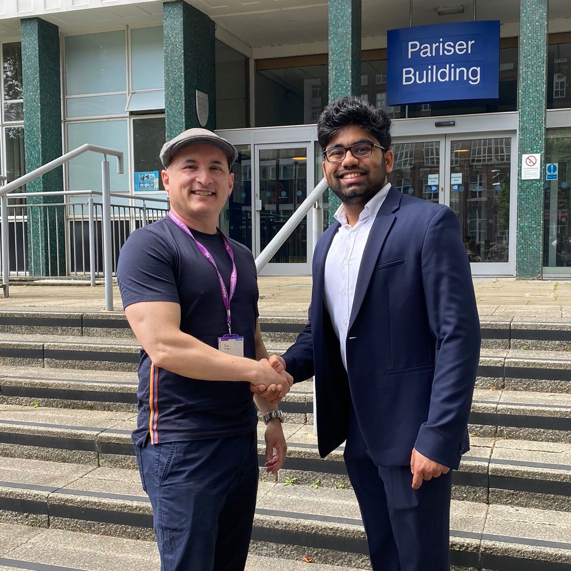 At the front steps to the Pariser Building, Chaitanya shakes hand with Professor Ian Stewart.