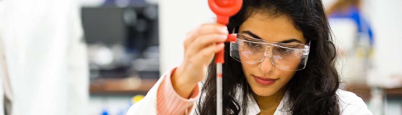 Scientist wearing protective glasses and holding a pipette