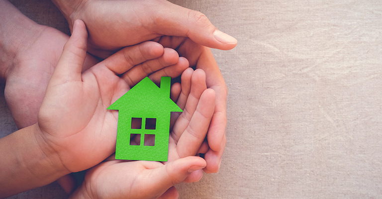 Small green house in adult and child's hands