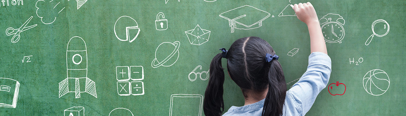 Young girl sketching on a blackboard
