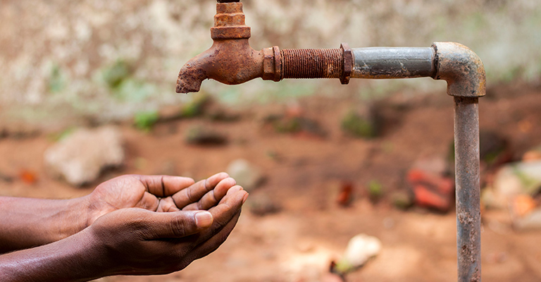 Hands under an empty water tap