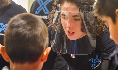 ScienceX volunteer speaks to children visitors