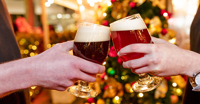 People clinking beer glasses at Christmas