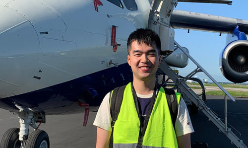 Chenjie Yu in front of an aeroplane