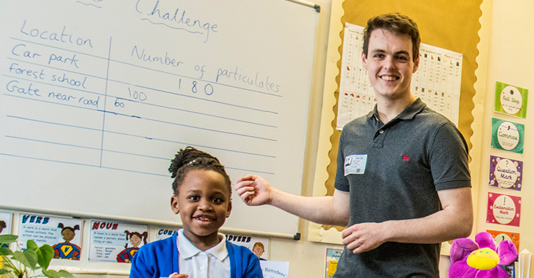 Link scientist Dan Blight and a pupil record their findings on a white board.