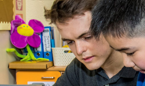 Scientist and school pupil working together