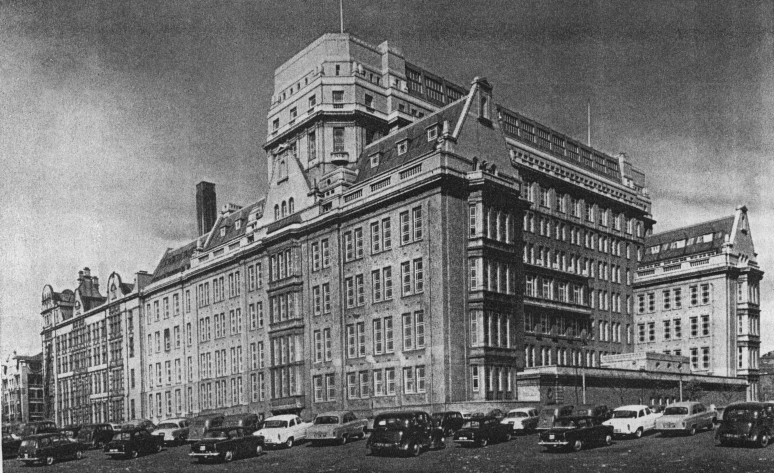 An old photograph of Sackville Street Building with cars parked outside it.