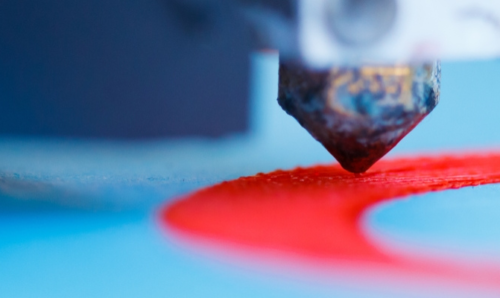 Close up of a 3D printer in action, with The Buzz logo in the corner.