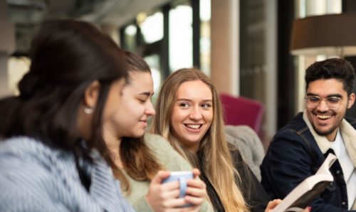 Four friends sat together reading and chatting
