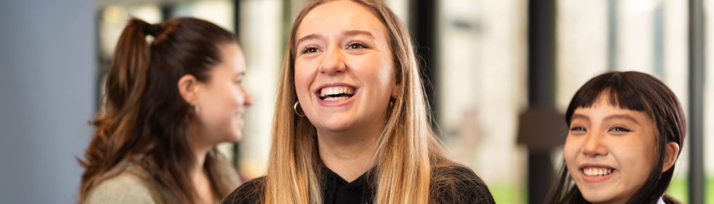 Students smiling at something out of view.