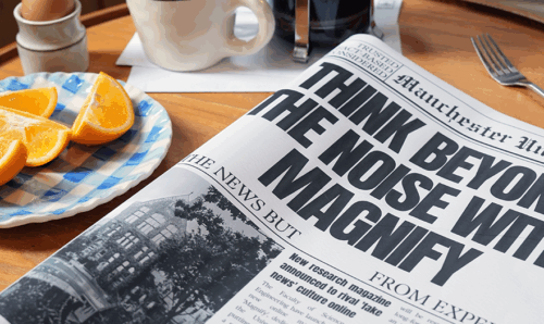 A plate of sliced oranges sits beside a newspaper reading 'Think beyond the noise with Magnify'