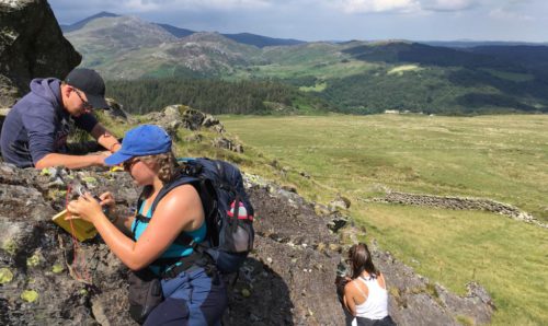 Students looking at rocks on a mountain