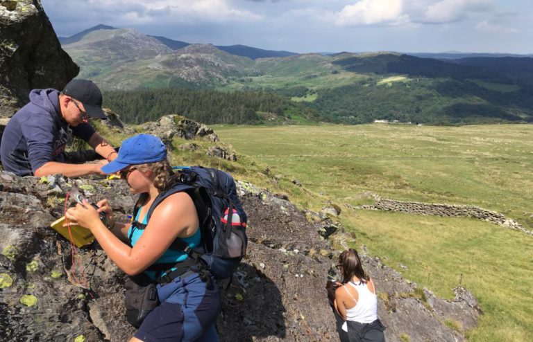 Students looking at rocks on a mountain