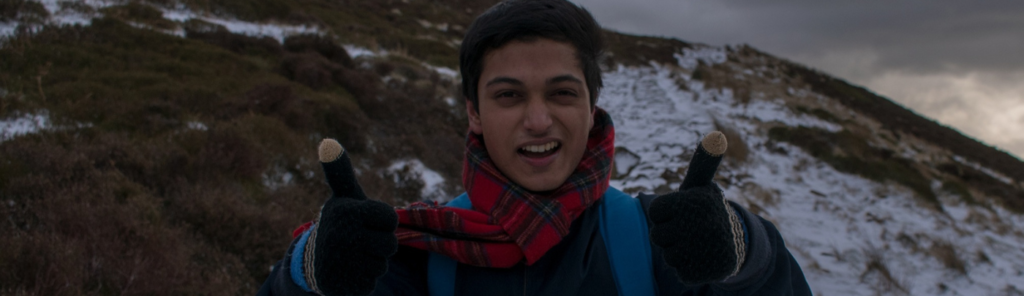 Wasim smiling on mountain with thumbs up