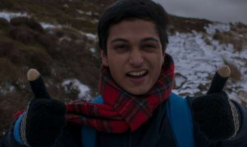 Wasim smiling on mountain with thumbs up