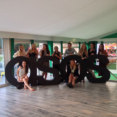 Ella and her team pose with the company's famous logo