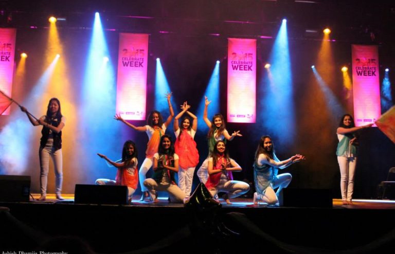 Aiswarya and 8 others on stage doing a performance of Indian Dance